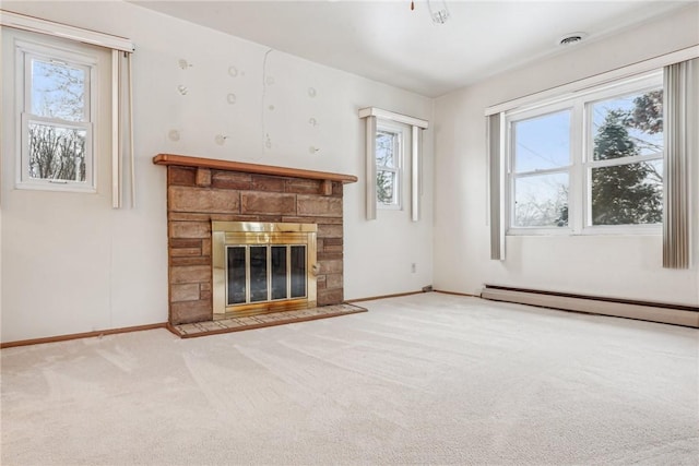 unfurnished living room with a wealth of natural light, light colored carpet, a stone fireplace, and a baseboard radiator