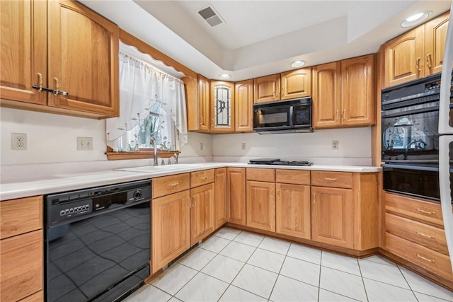 kitchen featuring light tile patterned floors, sink, and black appliances