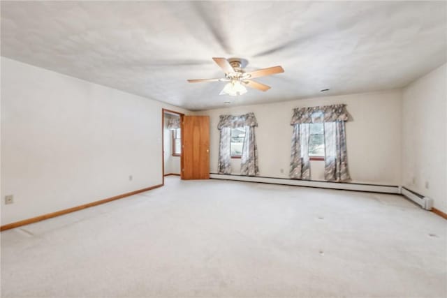 spare room with ceiling fan, baseboard heating, and carpet flooring