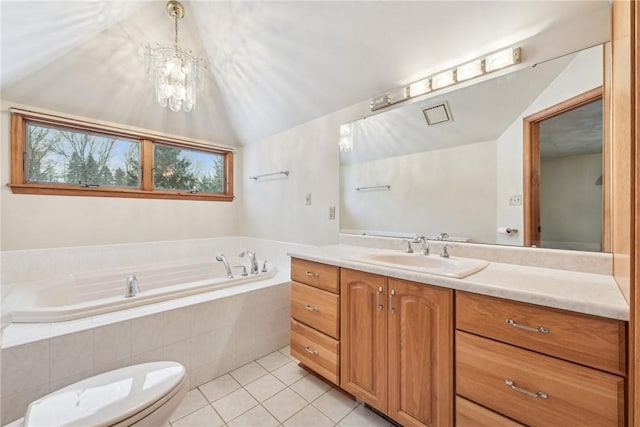 bathroom with lofted ceiling, tile patterned flooring, tiled tub, vanity, and toilet