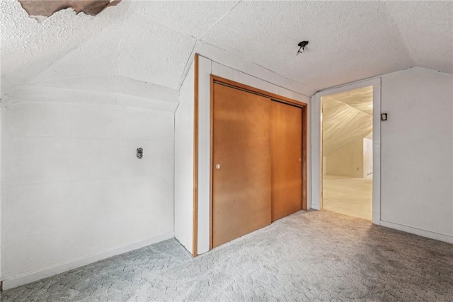 bonus room with carpet floors, vaulted ceiling, and a textured ceiling