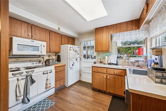 kitchen featuring light wood-type flooring and white appliances