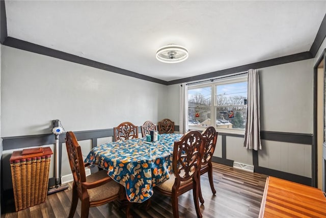 dining space featuring wood-type flooring and ornamental molding