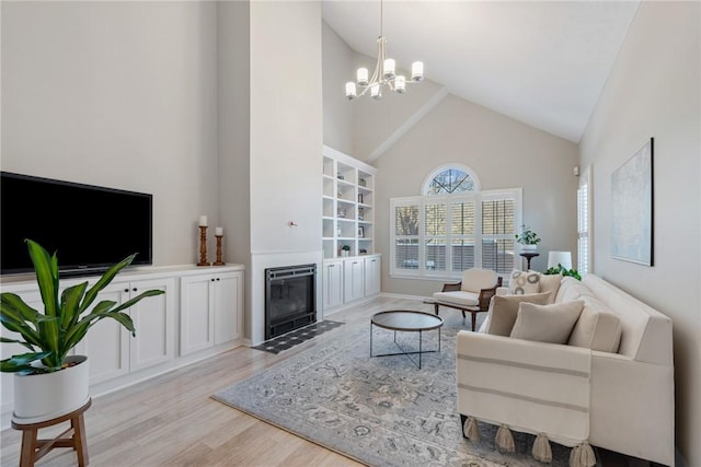 living room featuring light hardwood / wood-style floors, high vaulted ceiling, and a chandelier