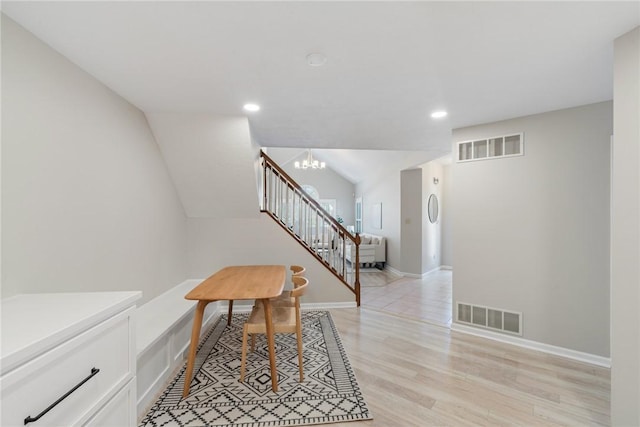 interior space featuring light hardwood / wood-style flooring, a chandelier, and vaulted ceiling