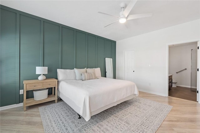 bedroom featuring ceiling fan, ensuite bathroom, and light hardwood / wood-style flooring