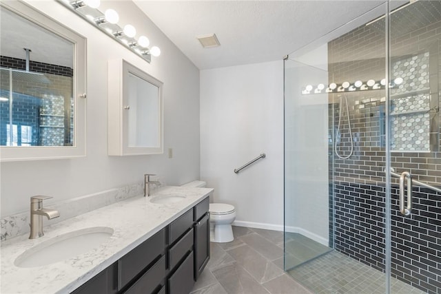 bathroom featuring toilet, a shower with shower door, and vanity