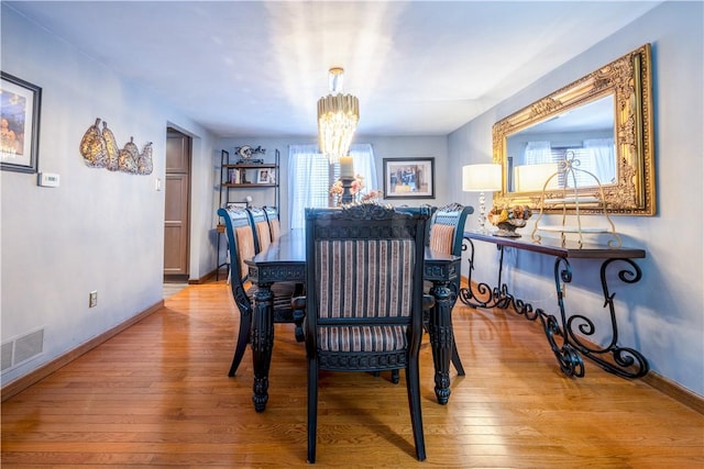 dining space featuring an inviting chandelier and light hardwood / wood-style floors