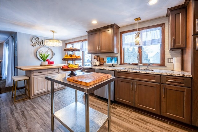 kitchen featuring sink, hanging light fixtures, dishwasher, and a notable chandelier