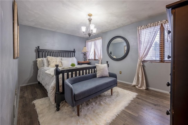 bedroom featuring dark hardwood / wood-style flooring and a chandelier