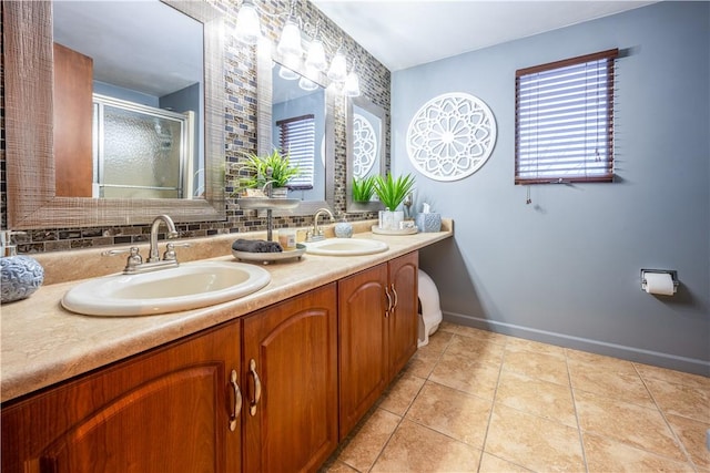 bathroom with tile patterned flooring, decorative backsplash, a shower with shower door, and vanity