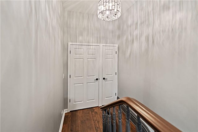 corridor featuring dark hardwood / wood-style floors and a chandelier