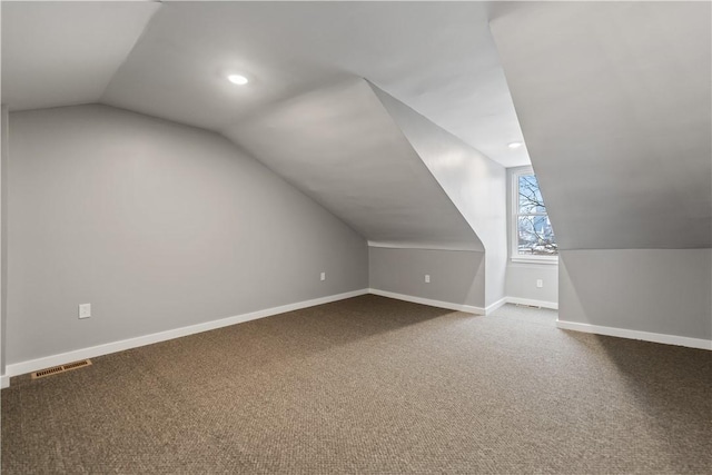 bonus room with vaulted ceiling and carpet floors