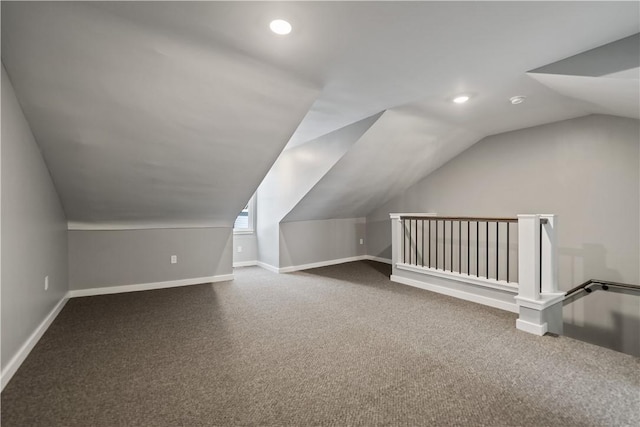 bonus room with vaulted ceiling and carpet flooring