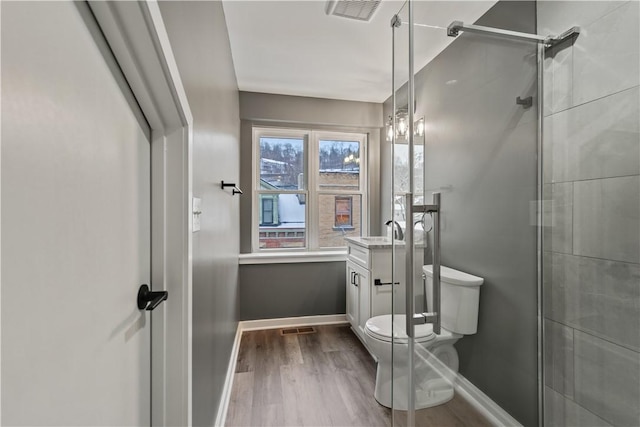 bathroom featuring toilet, vanity, an enclosed shower, and hardwood / wood-style flooring