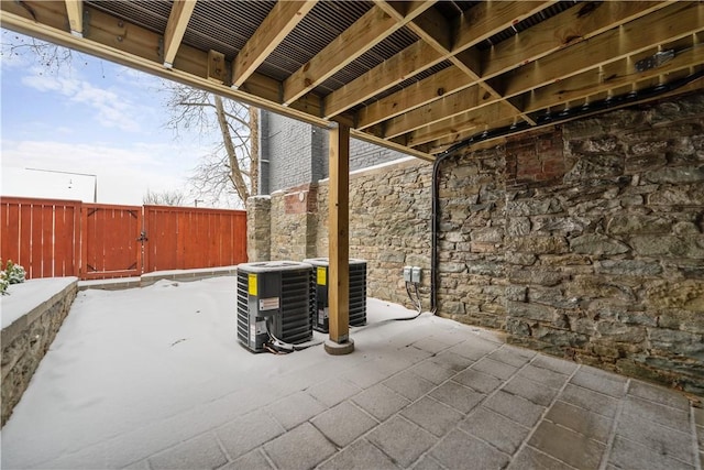 snow covered patio featuring cooling unit