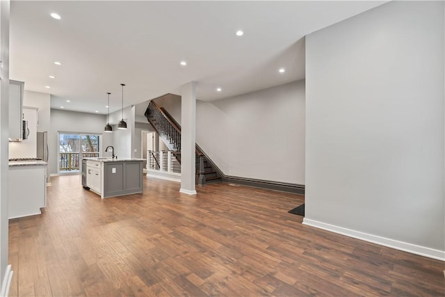 unfurnished living room featuring dark hardwood / wood-style floors and sink