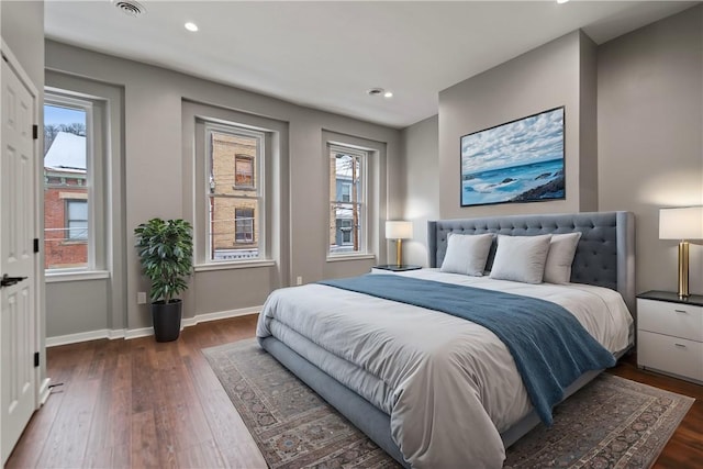 bedroom featuring multiple windows and dark hardwood / wood-style floors