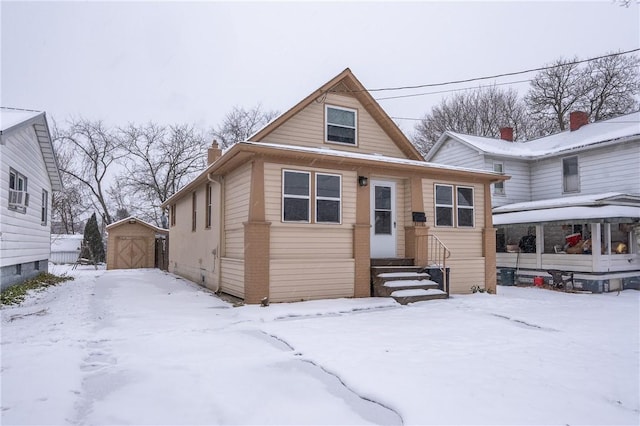 bungalow-style house with a storage shed