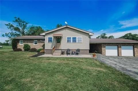 view of front of home with a front yard and a garage