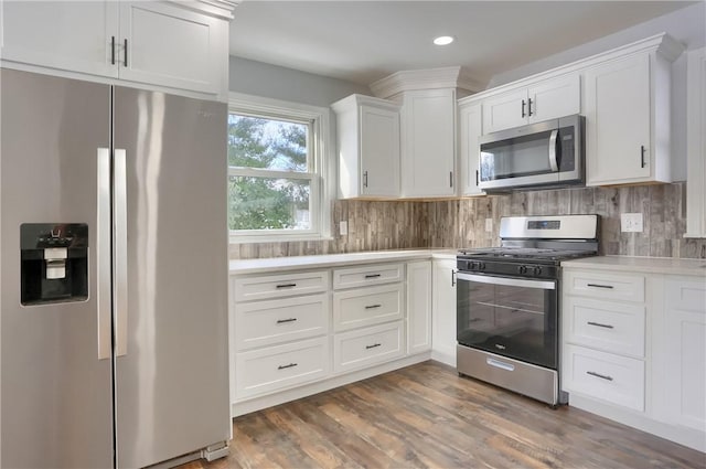 kitchen featuring dark wood-type flooring, white cabinetry, stainless steel appliances, and tasteful backsplash