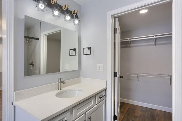 bathroom featuring walk in shower, hardwood / wood-style floors, and vanity