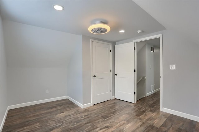 interior space featuring lofted ceiling and dark wood-type flooring