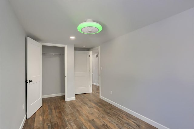 unfurnished bedroom featuring a closet and dark hardwood / wood-style flooring