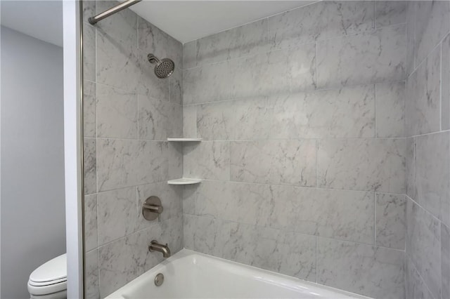 bathroom with toilet and tiled shower / bath