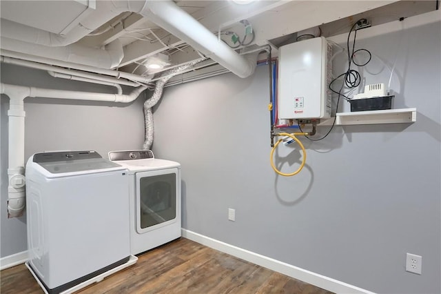 laundry room with dark wood-type flooring, tankless water heater, and washing machine and clothes dryer