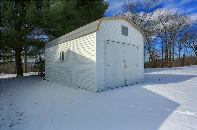 snow covered structure with a garage