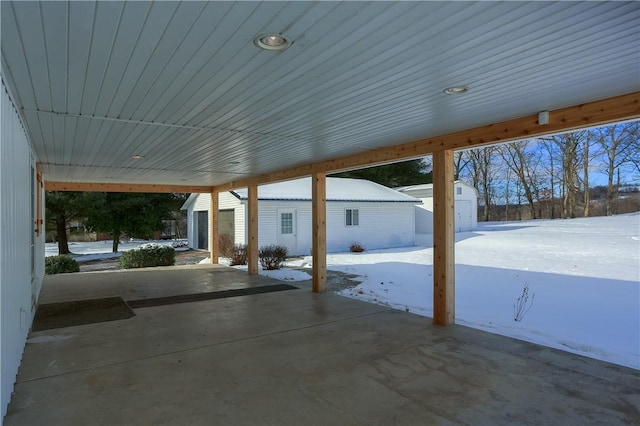 snow covered patio with a storage shed