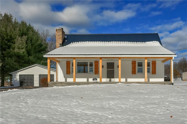 view of front of home featuring covered porch, a garage, and an outbuilding