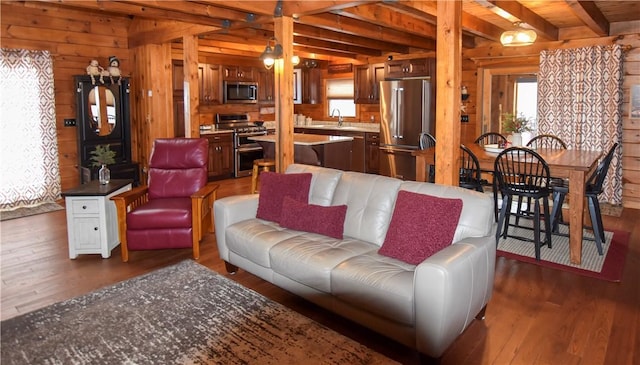 living room with a wealth of natural light, dark hardwood / wood-style flooring, wood ceiling, and beamed ceiling