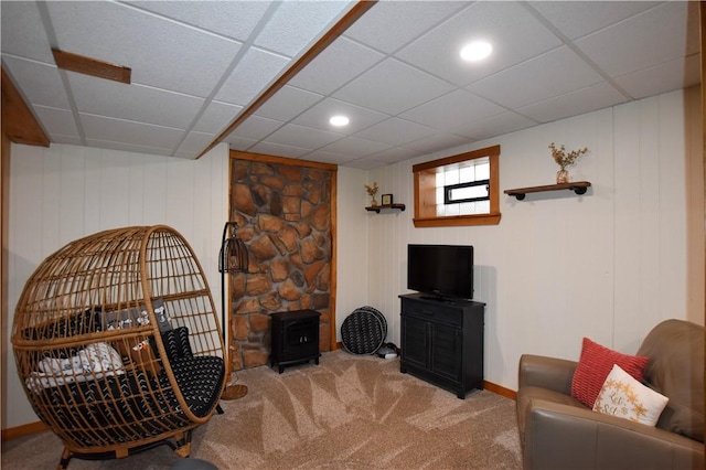 carpeted living room featuring a drop ceiling