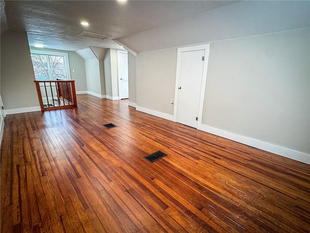 bonus room with dark hardwood / wood-style floors and lofted ceiling