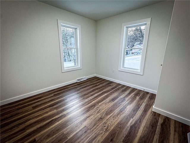 spare room featuring dark wood-type flooring