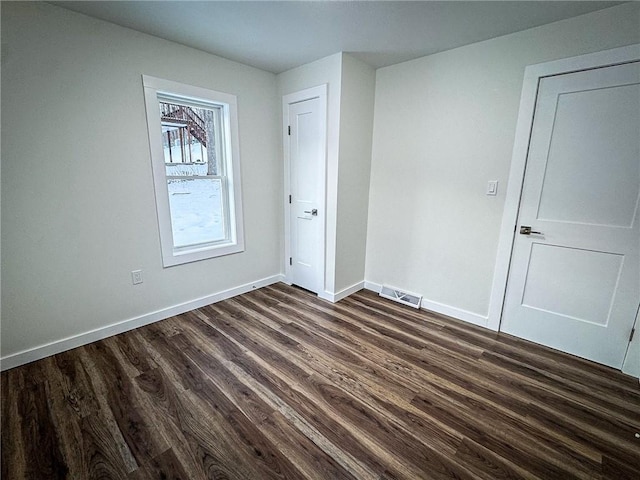 unfurnished room with dark hardwood / wood-style flooring