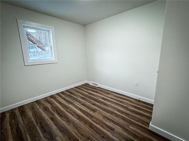 unfurnished room with dark wood-type flooring