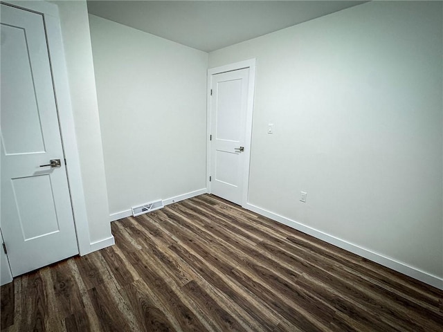 empty room with dark hardwood / wood-style flooring