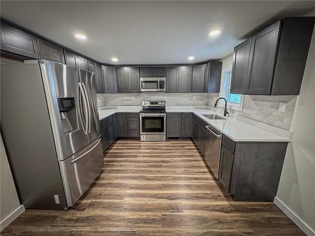 kitchen with decorative backsplash, sink, appliances with stainless steel finishes, and dark hardwood / wood-style flooring