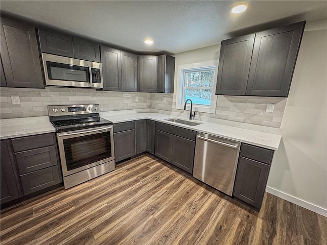 kitchen featuring sink, dark brown cabinetry, appliances with stainless steel finishes, and dark hardwood / wood-style floors