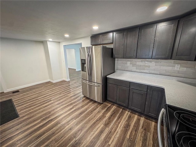 kitchen featuring decorative backsplash, dark brown cabinetry, range with electric stovetop, dark wood-type flooring, and stainless steel fridge with ice dispenser