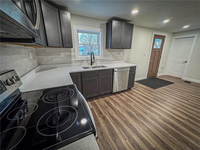 kitchen featuring light stone countertops, appliances with stainless steel finishes, dark hardwood / wood-style flooring, tasteful backsplash, and sink