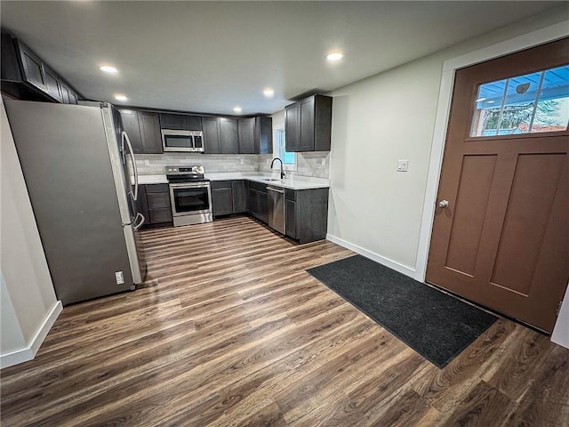 kitchen with stainless steel appliances, decorative backsplash, dark hardwood / wood-style floors, and sink