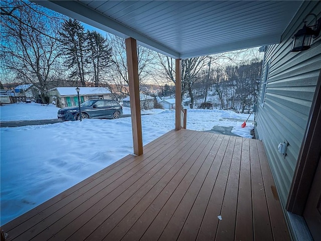 snow covered deck featuring a porch