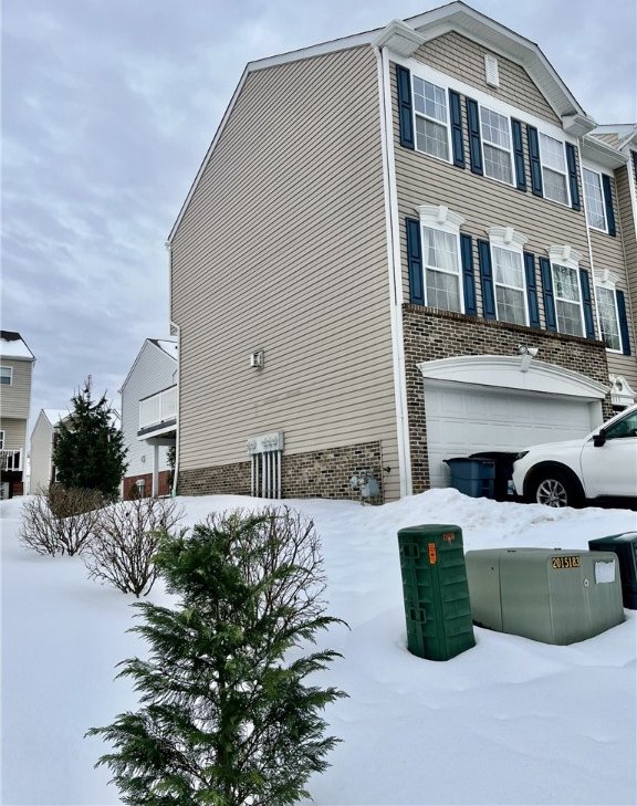 view of snow covered exterior featuring a garage