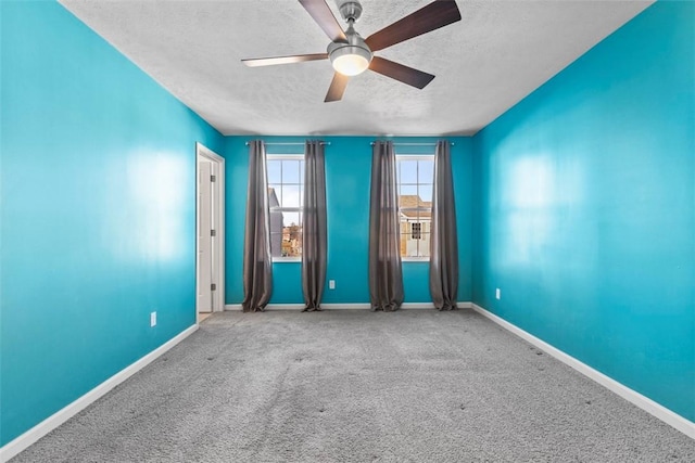 carpeted empty room featuring ceiling fan and a textured ceiling