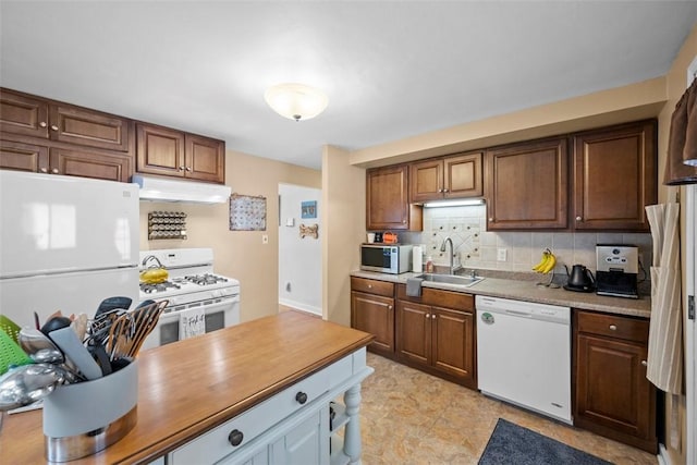 kitchen featuring decorative backsplash, sink, and white appliances