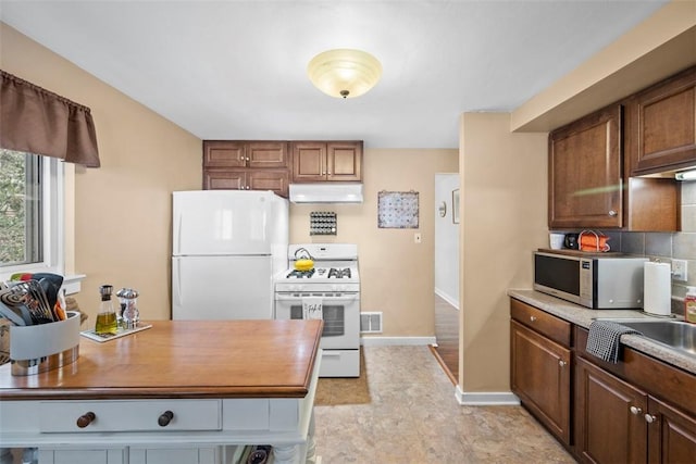 kitchen featuring decorative backsplash and white appliances